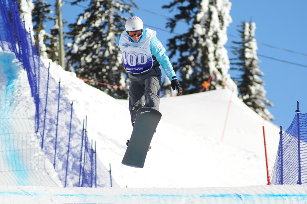 Man on snowboard flies over a jump