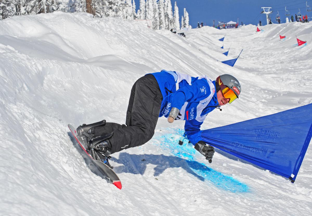 Man on snowboard turns on a banked slope