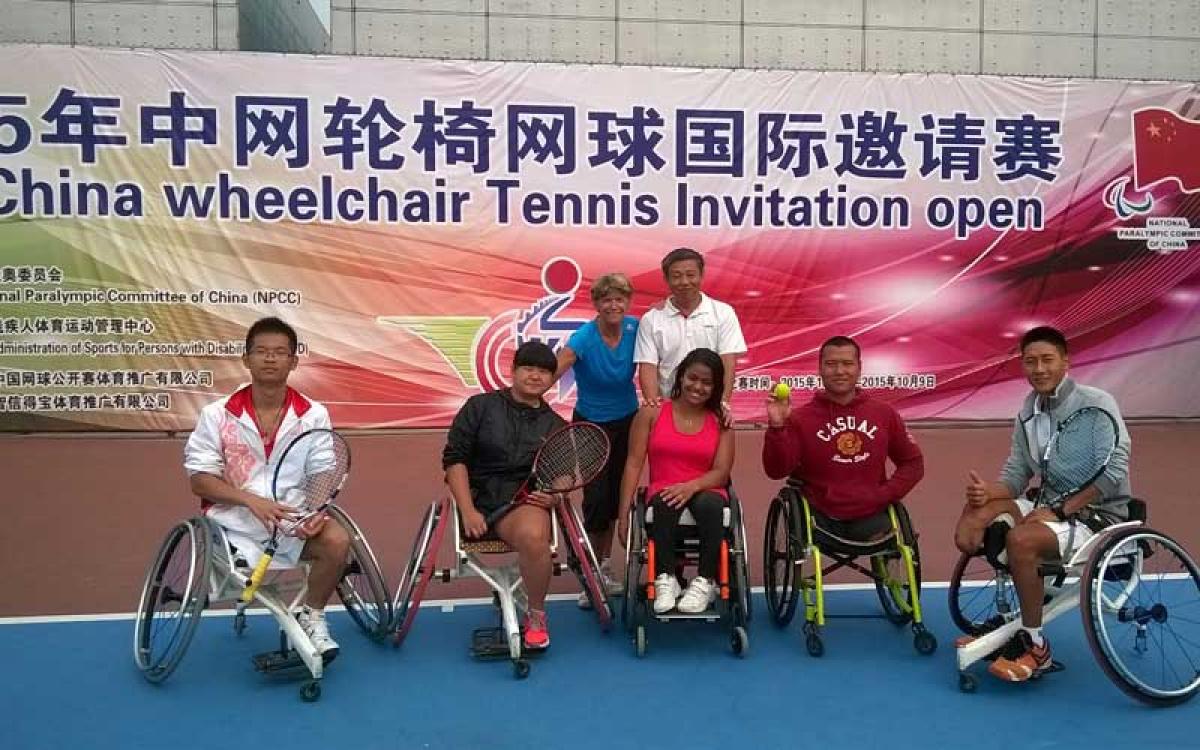 Group picture on a tennis court with some people in wheelchairs