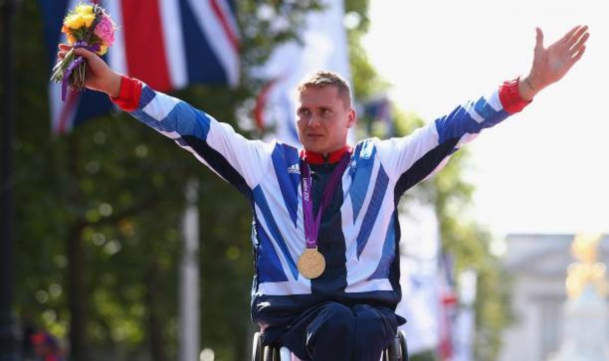 David Weir A picture of a man in wheelchair celebrating his victory with a gold medal around his neck