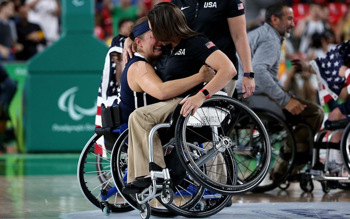 Two women in wheelchairs hugging each other
