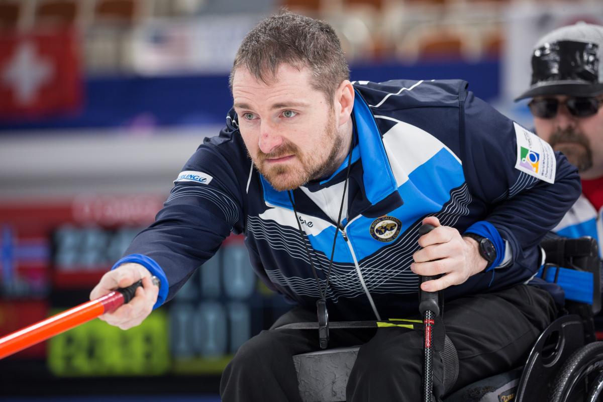 Scotland - wheelchair curling - 2017 World Championships Man in blue training suit and in wheelchair focusing on something behind the camera
