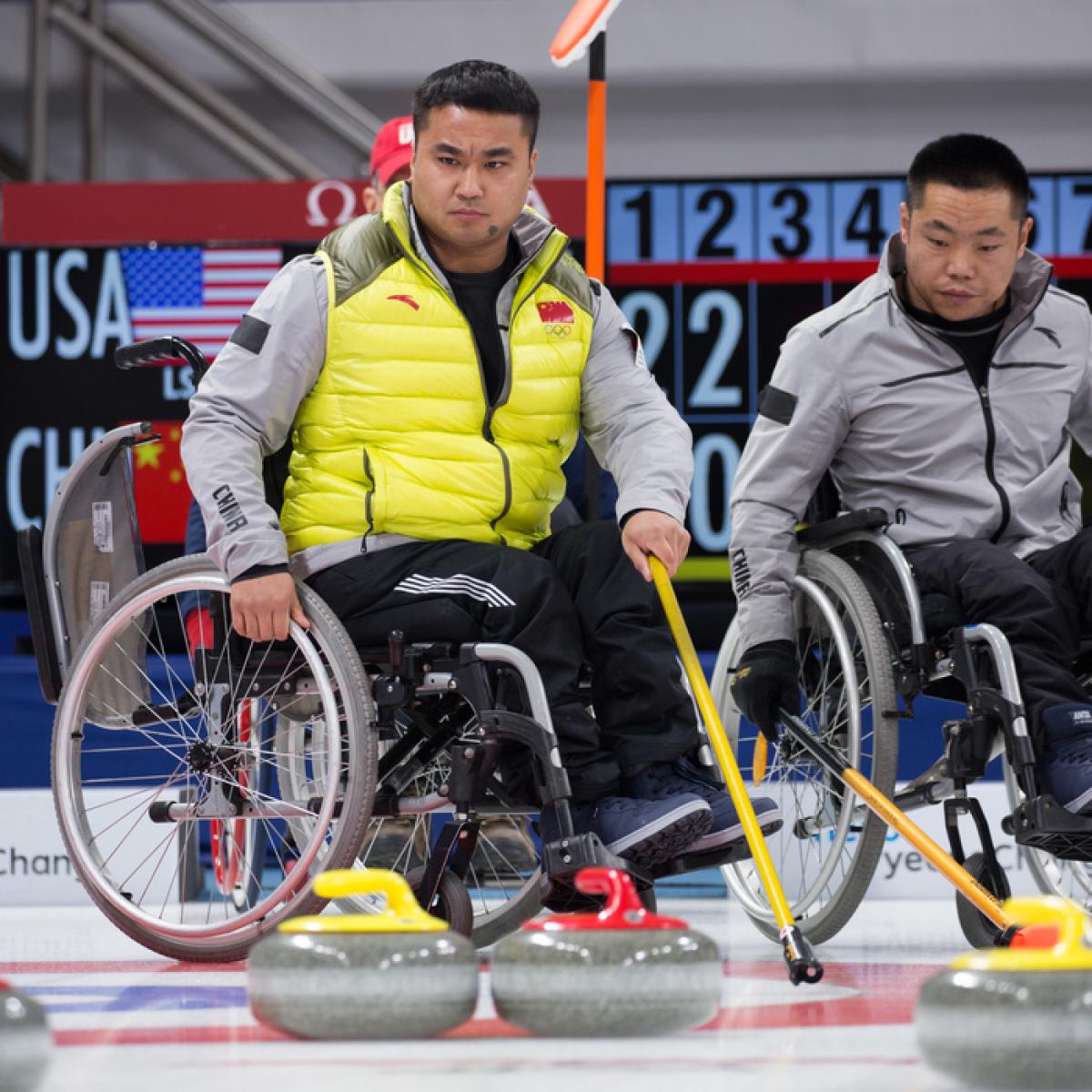 Chinese wheelchair curling players watching the stones