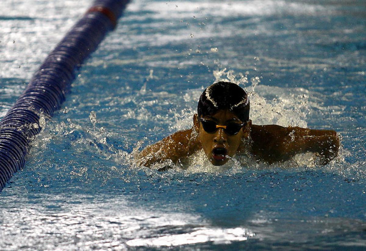 Boy with swim cap and goggles swims