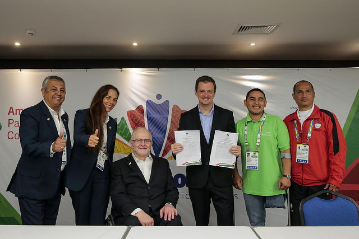 People pose for photo after a partnership agreement is signed