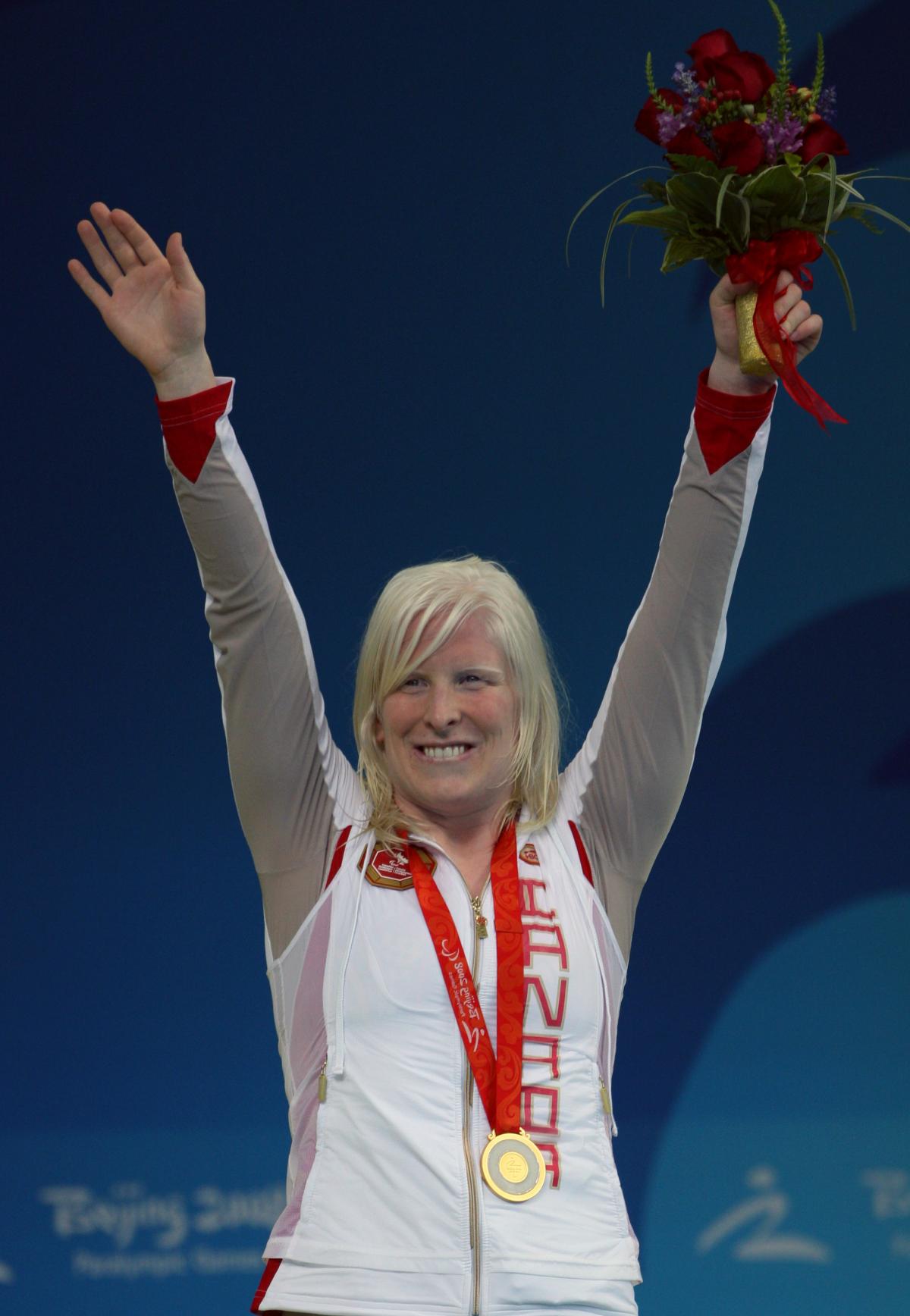 Canada's Chelsey Gotell - swimming Swimmer raises her arms on the podium to celebrate her medal