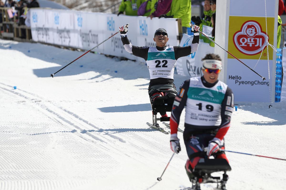 A sit skier celebrates his performance