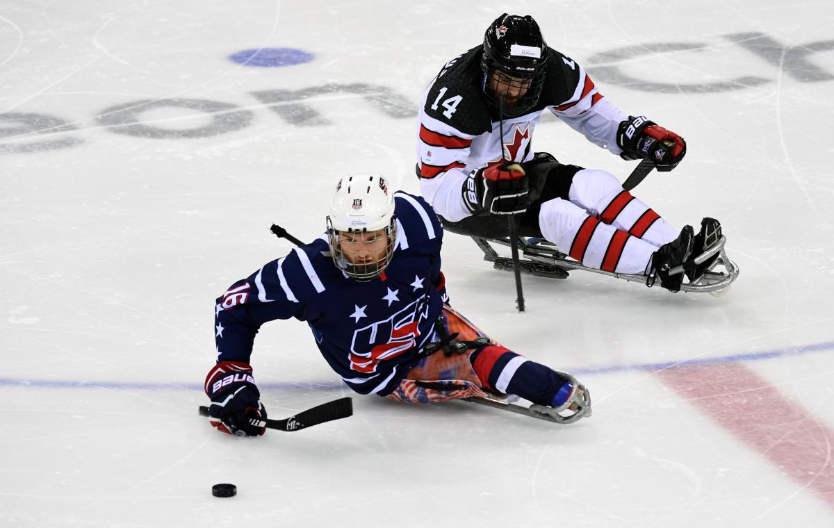 Man on ice hockey sledge makes a move with the puck