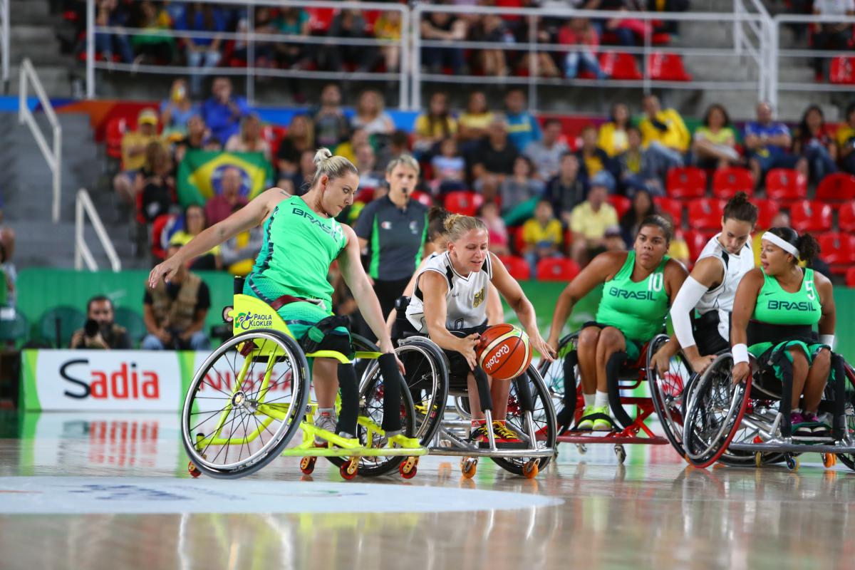 Laura Furst - Germany wheelchair basketball Woman in wheelchair goes for loose basketball while oppents guard her