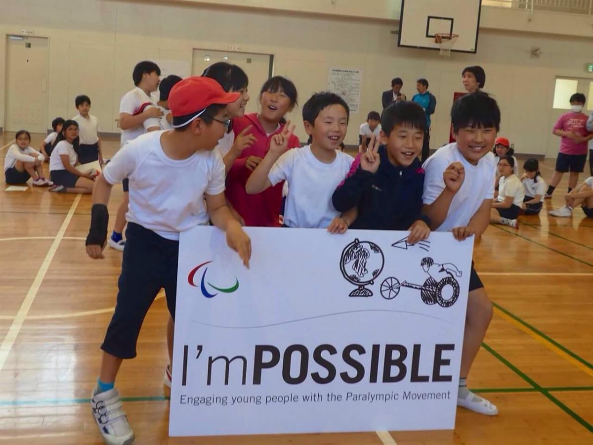 Group of Japanese kids holding up a sign