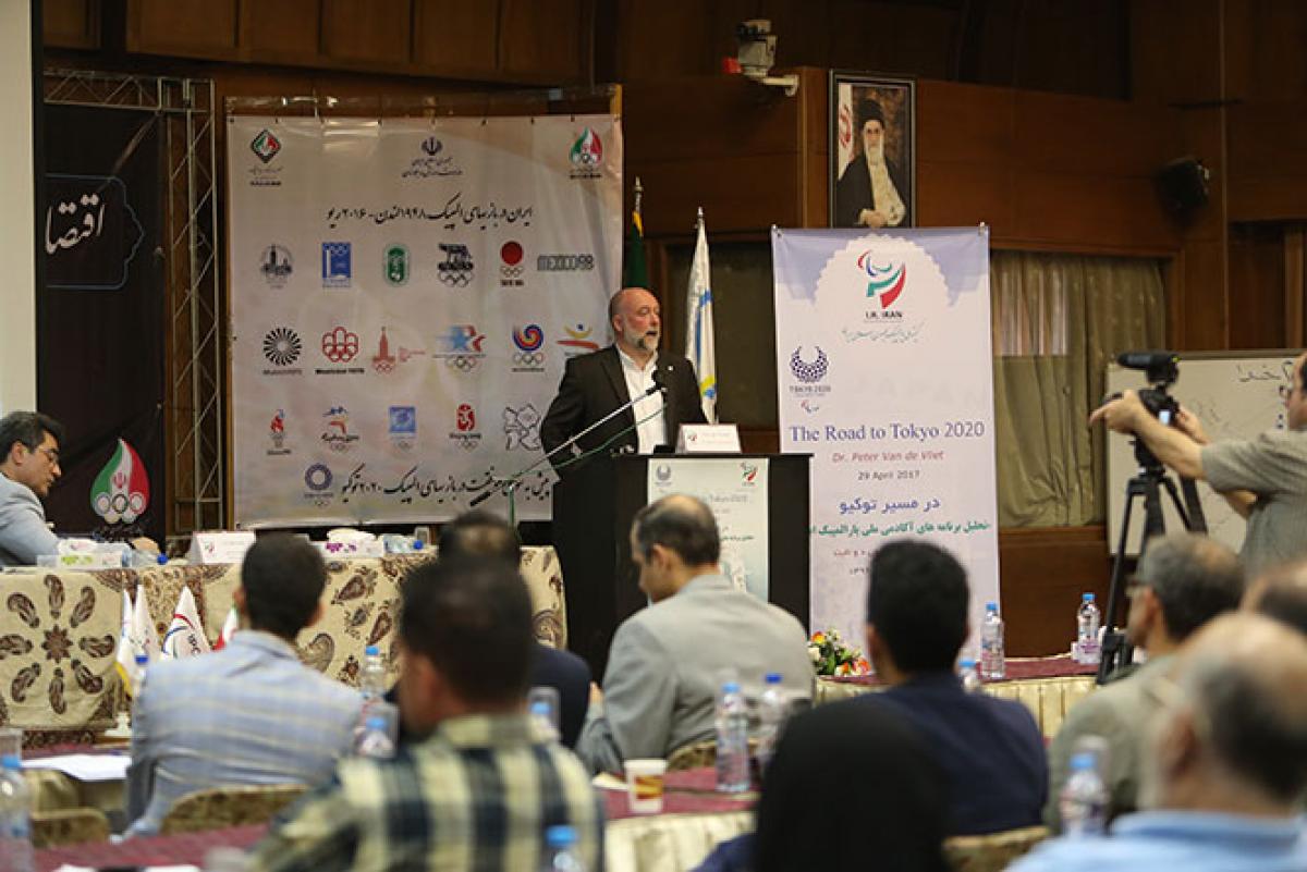 Man speaks to a crowd of people attending a seminar