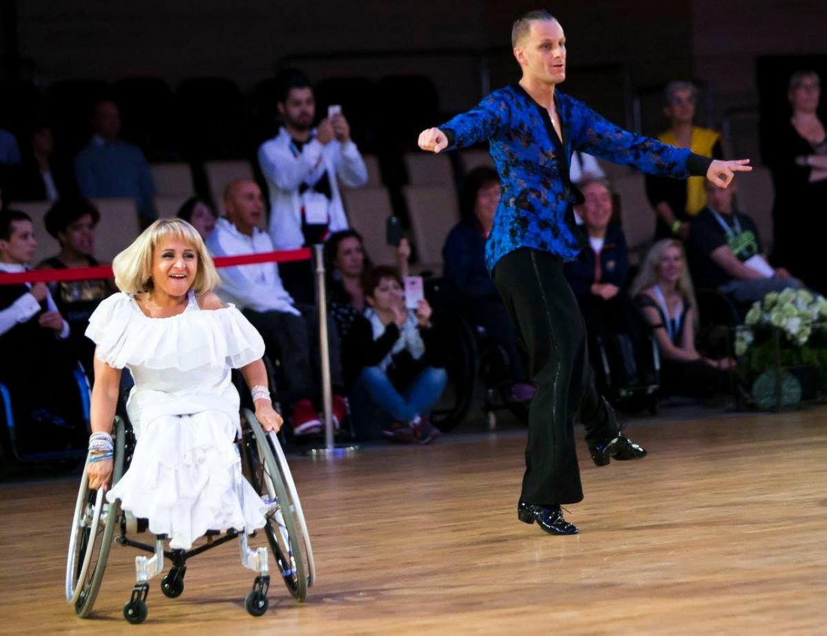 Woman in wheelchair dances with standing male partner 