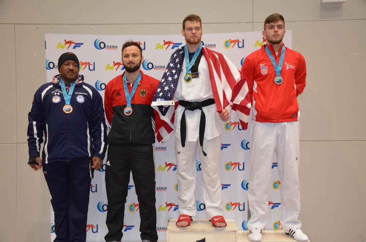 Taekwondo men standing on podium