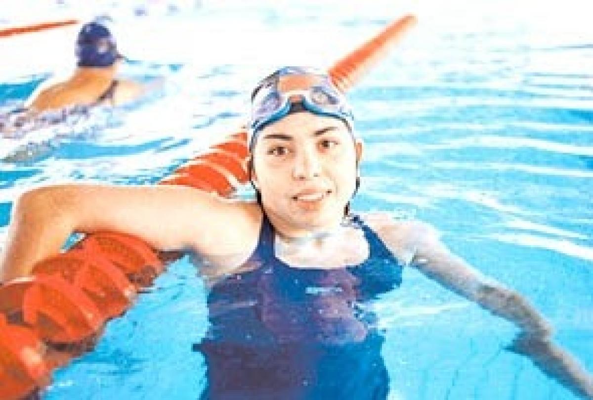 female swimmer celebrates in pool after winning race