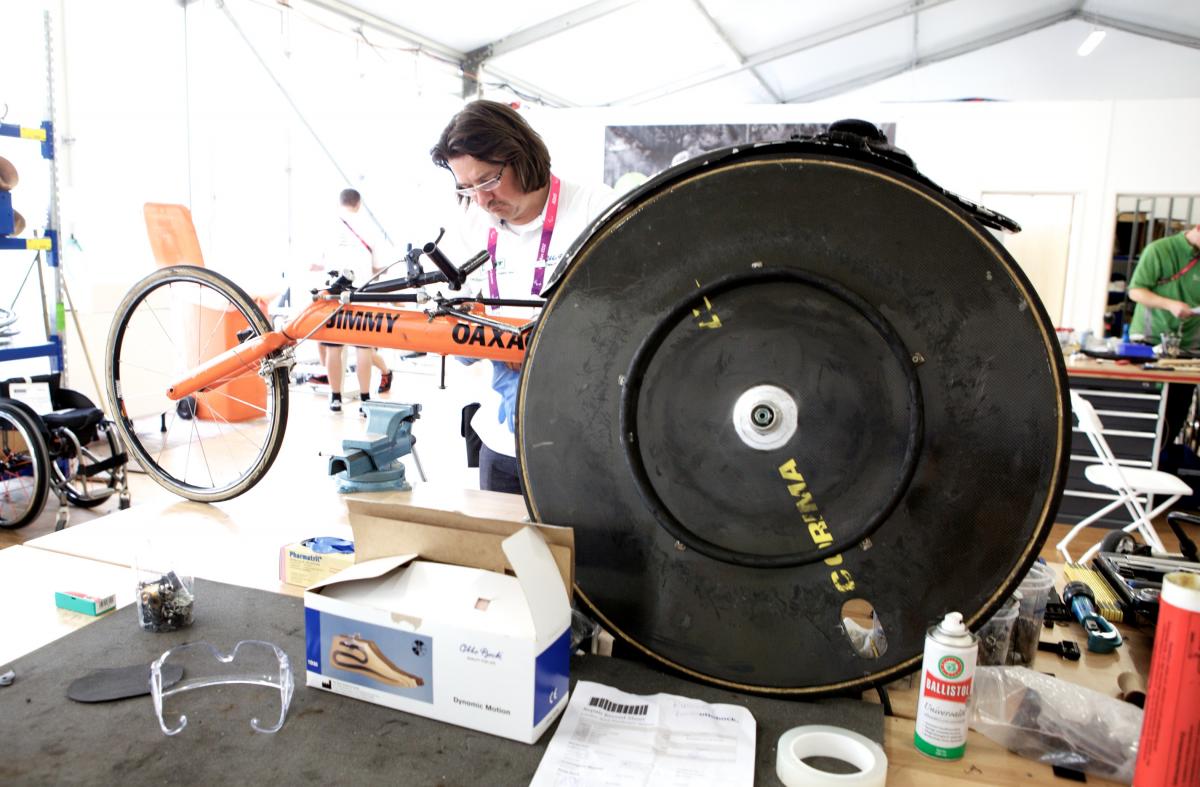 men repairing racing wheelchair