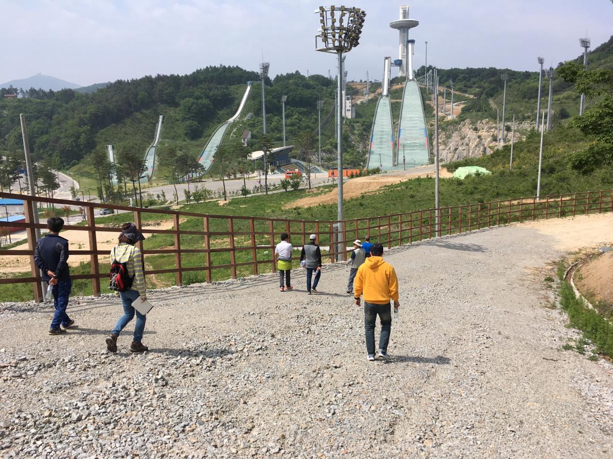 snowless skiing course being inspected by two men