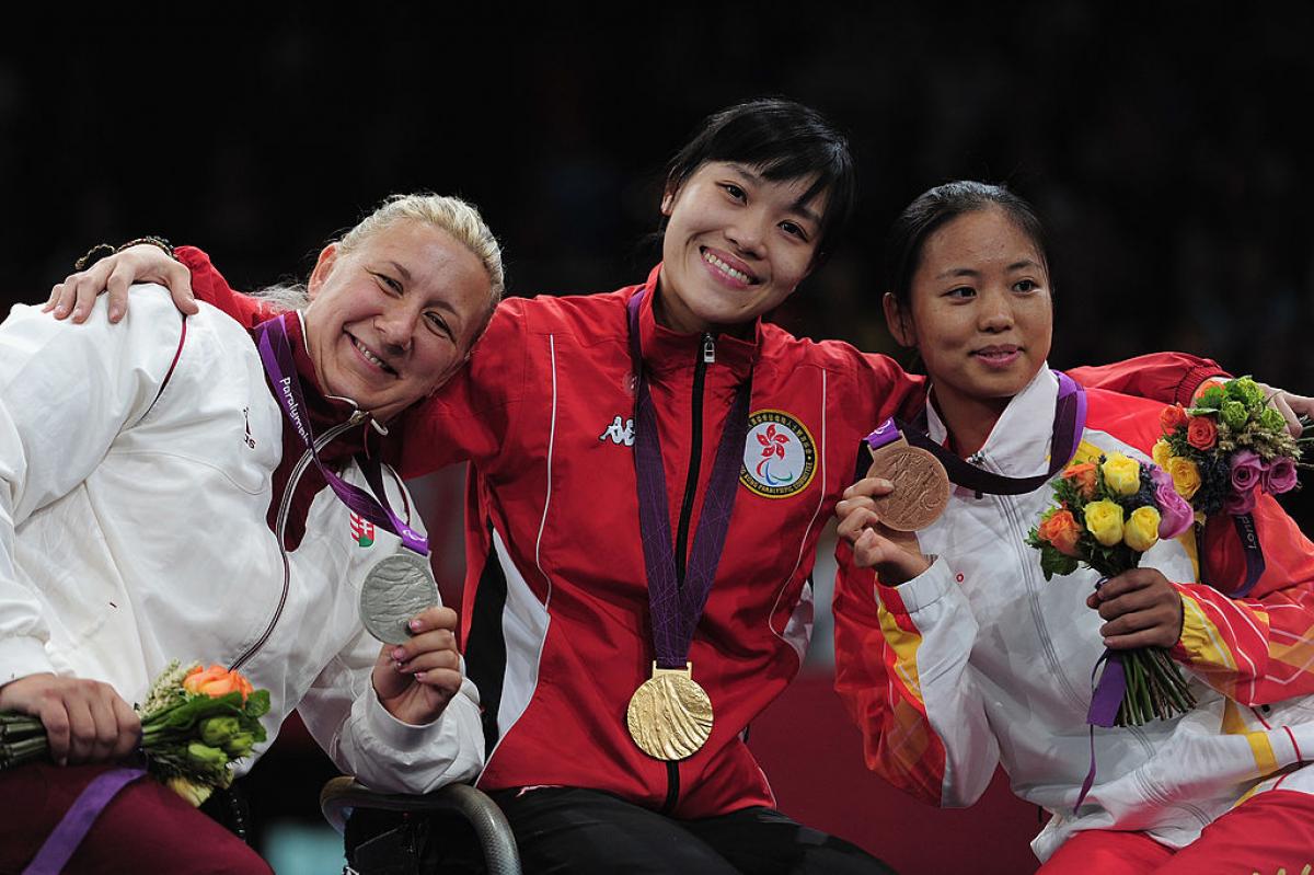 three women with medals standing on a podium