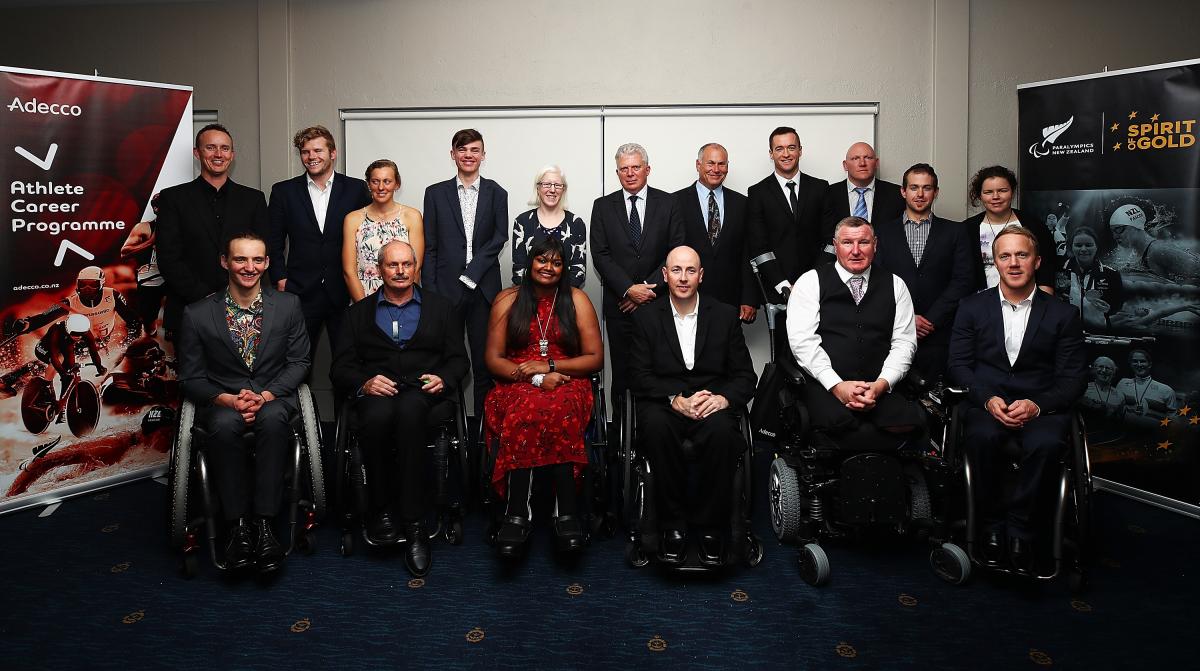 a group of athletes in evening dress smile for the camera