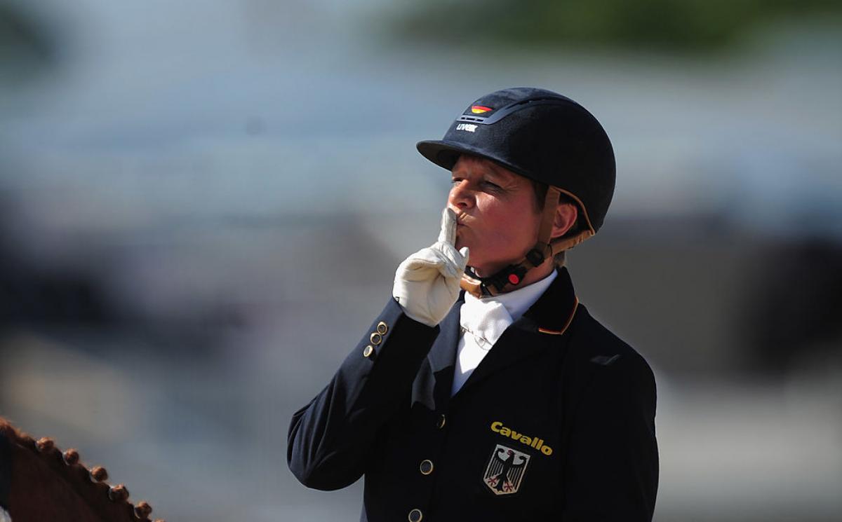 A female rider puts her finger to her lips