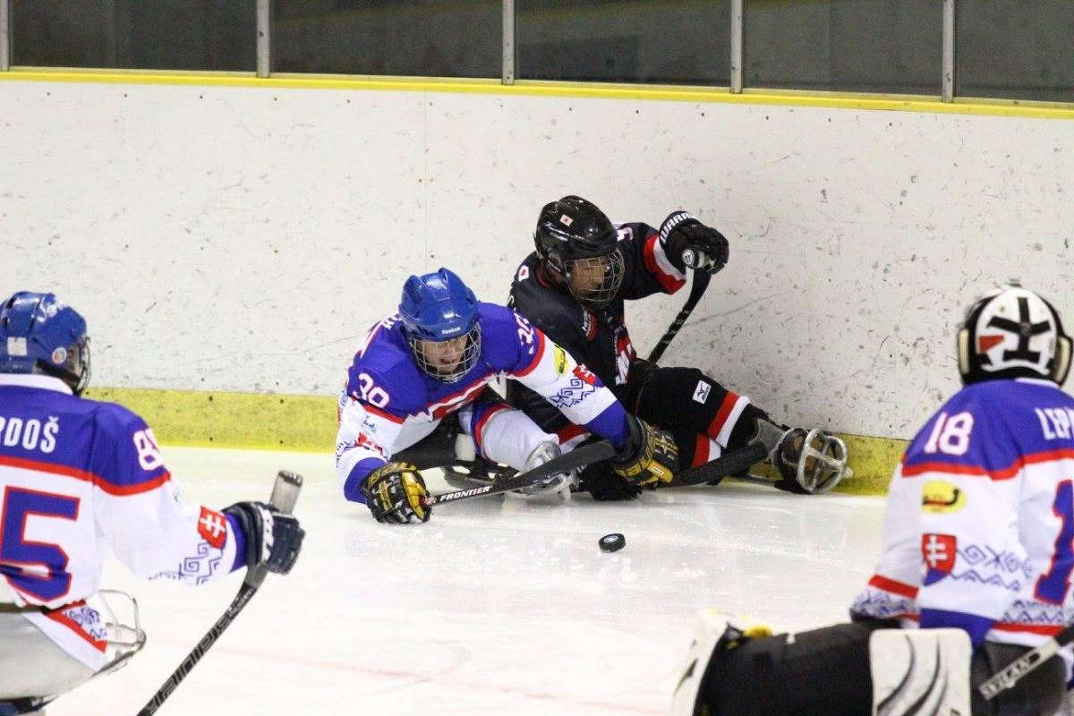 a group of para ice hockey players fight for the puck