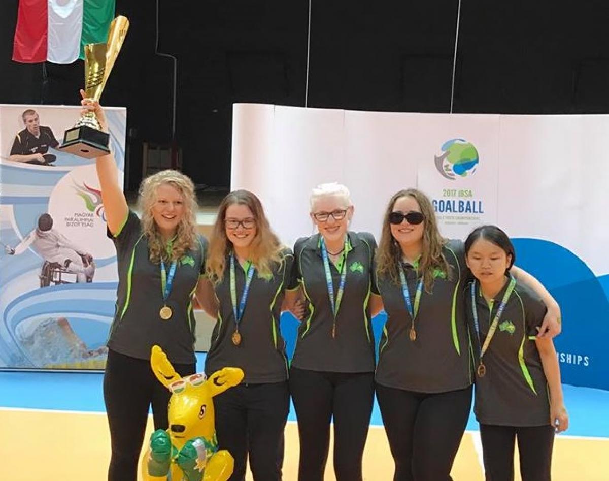 Australia youth women goalball team A group of female athletes celebrate with a trophy
