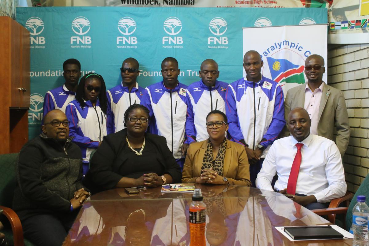 a group of Para athletes and officials pose for a photo