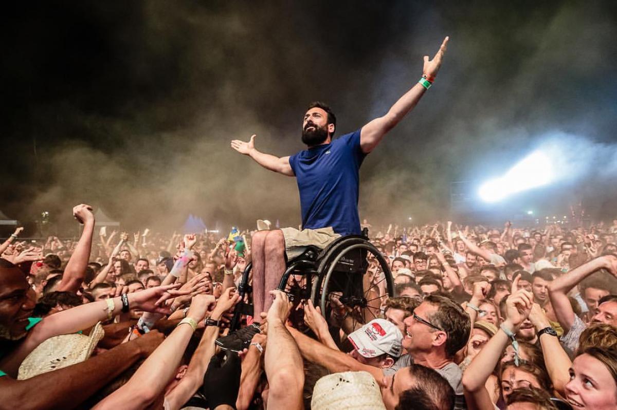 a man in a wheelchair crowd surfs