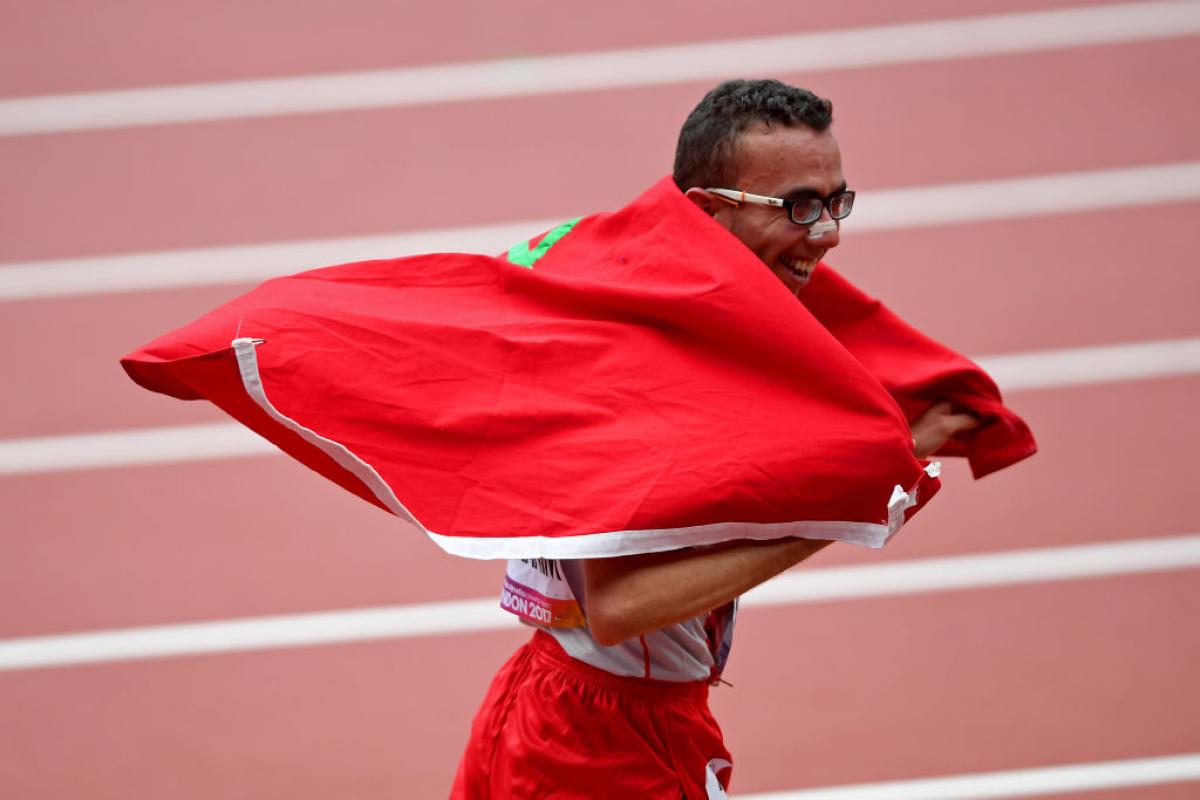 Man in running clothes celebrates with Morocco flag
