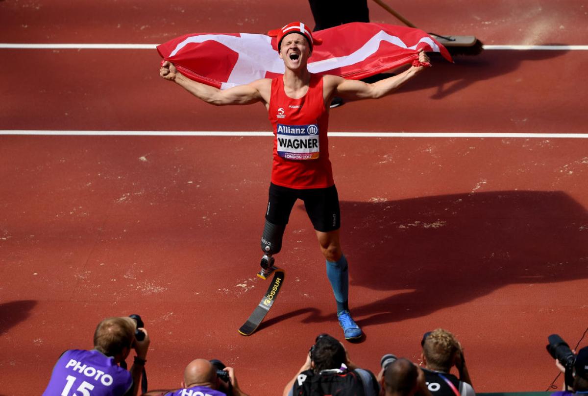 a para athlete celebrates with a flag