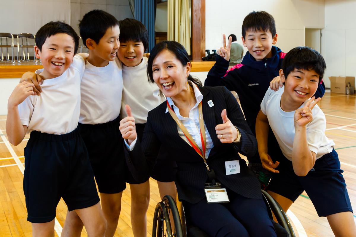 A group of children pose with a wheelchair athlete