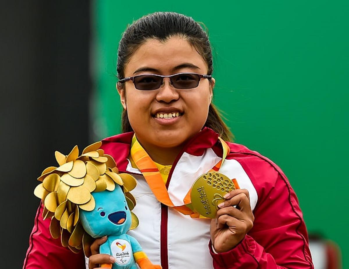 a para archer celebrates with her gold medal