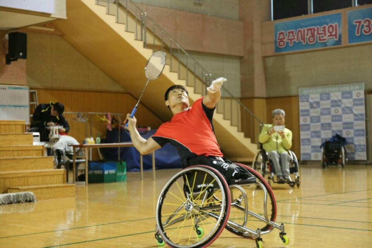Jung Jun Kim a para badminton player in a wheelchair goes for a shot