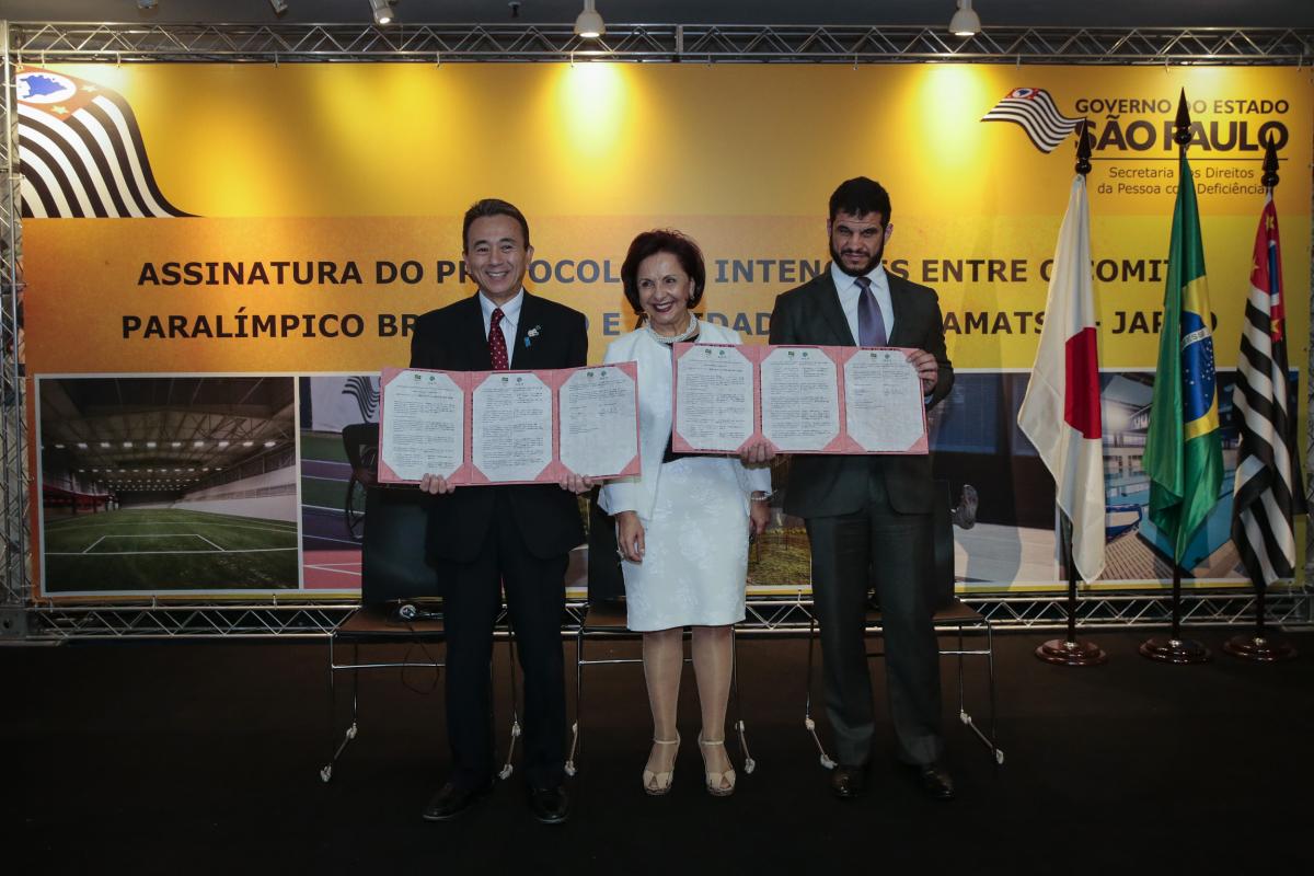 NPC Brazil 2020 training camp two men and a woman stand and smile for the camera