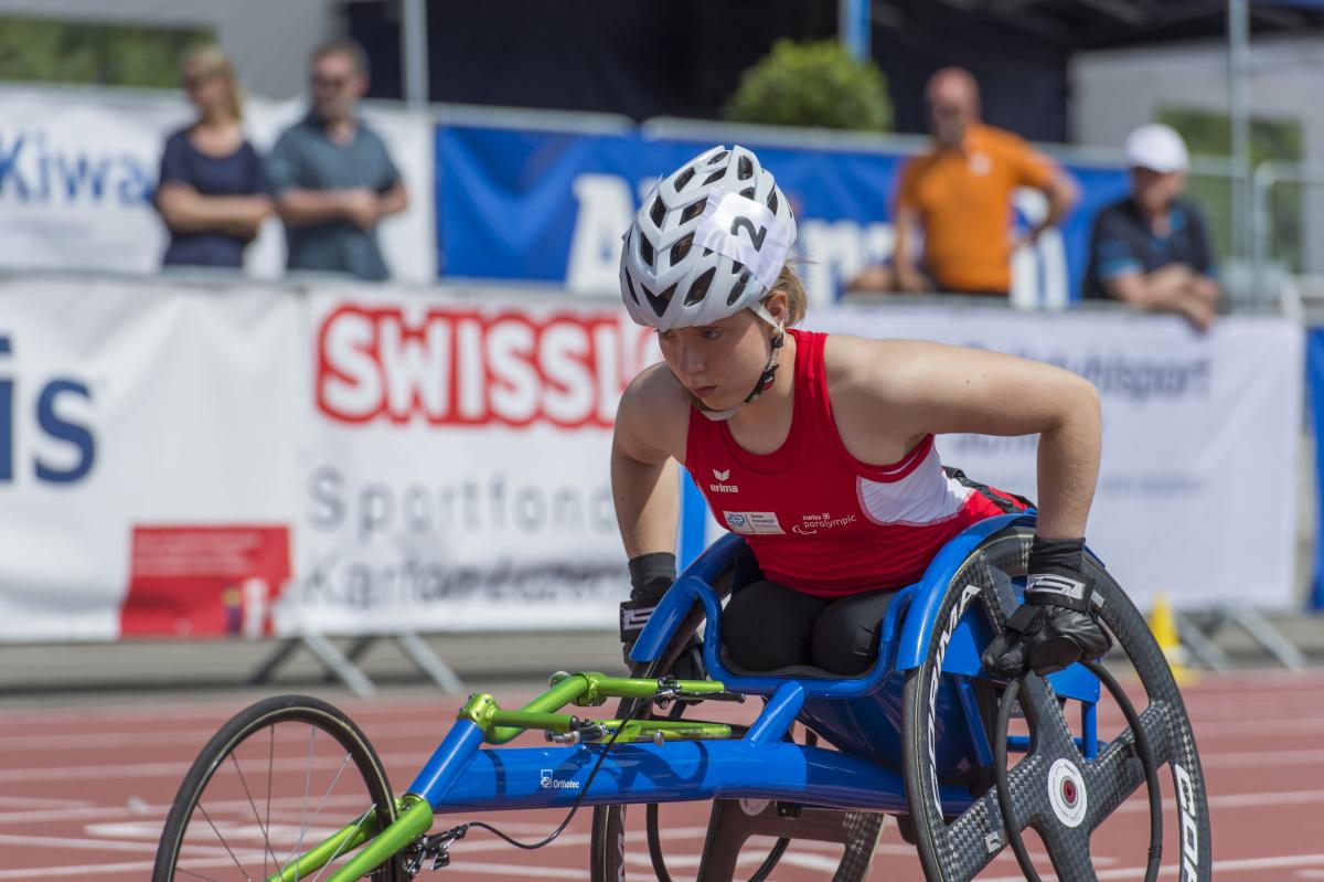 a female wheelchair racer lines up for the start of a race