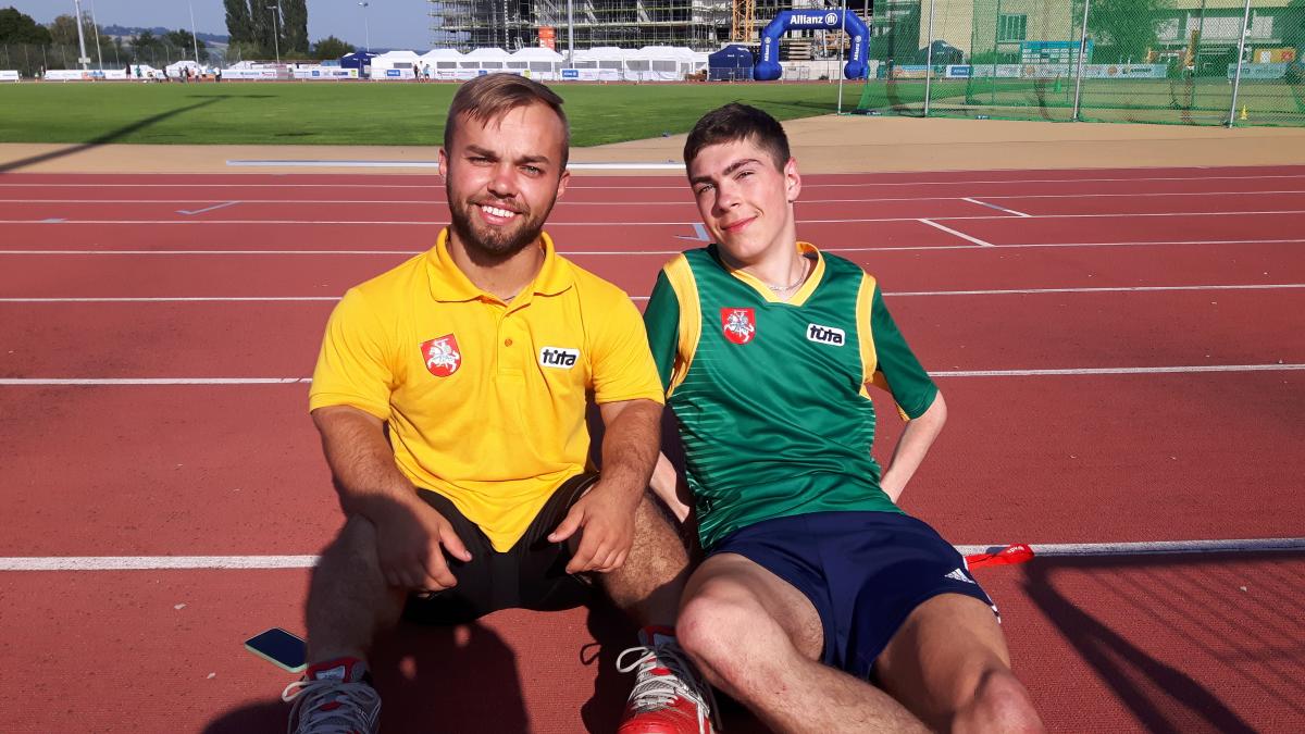 two male para athletes sit together on the track