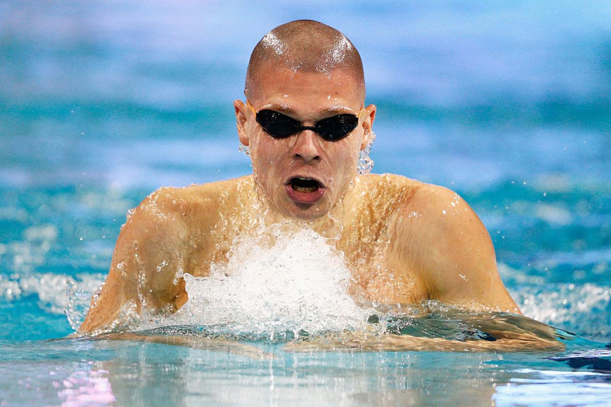 a para swimmer comes out of the water to take a breath