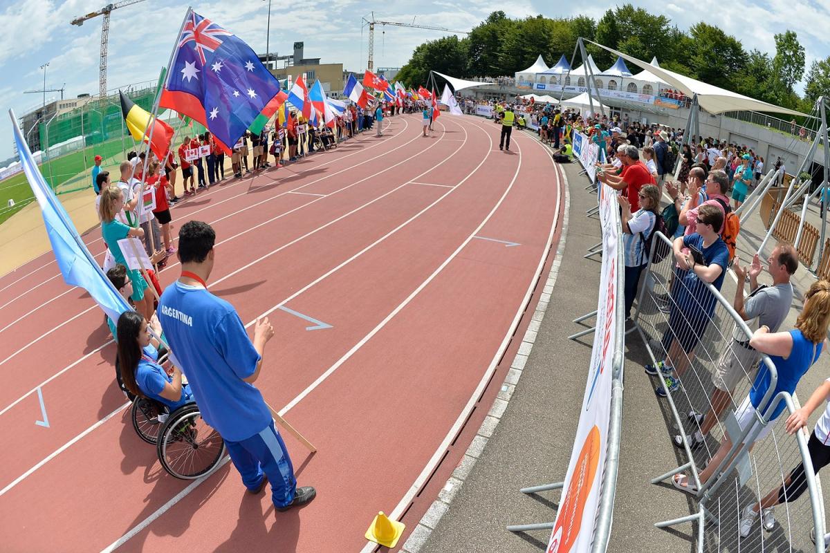 Teams holding flags on the track for Opening Ceremony