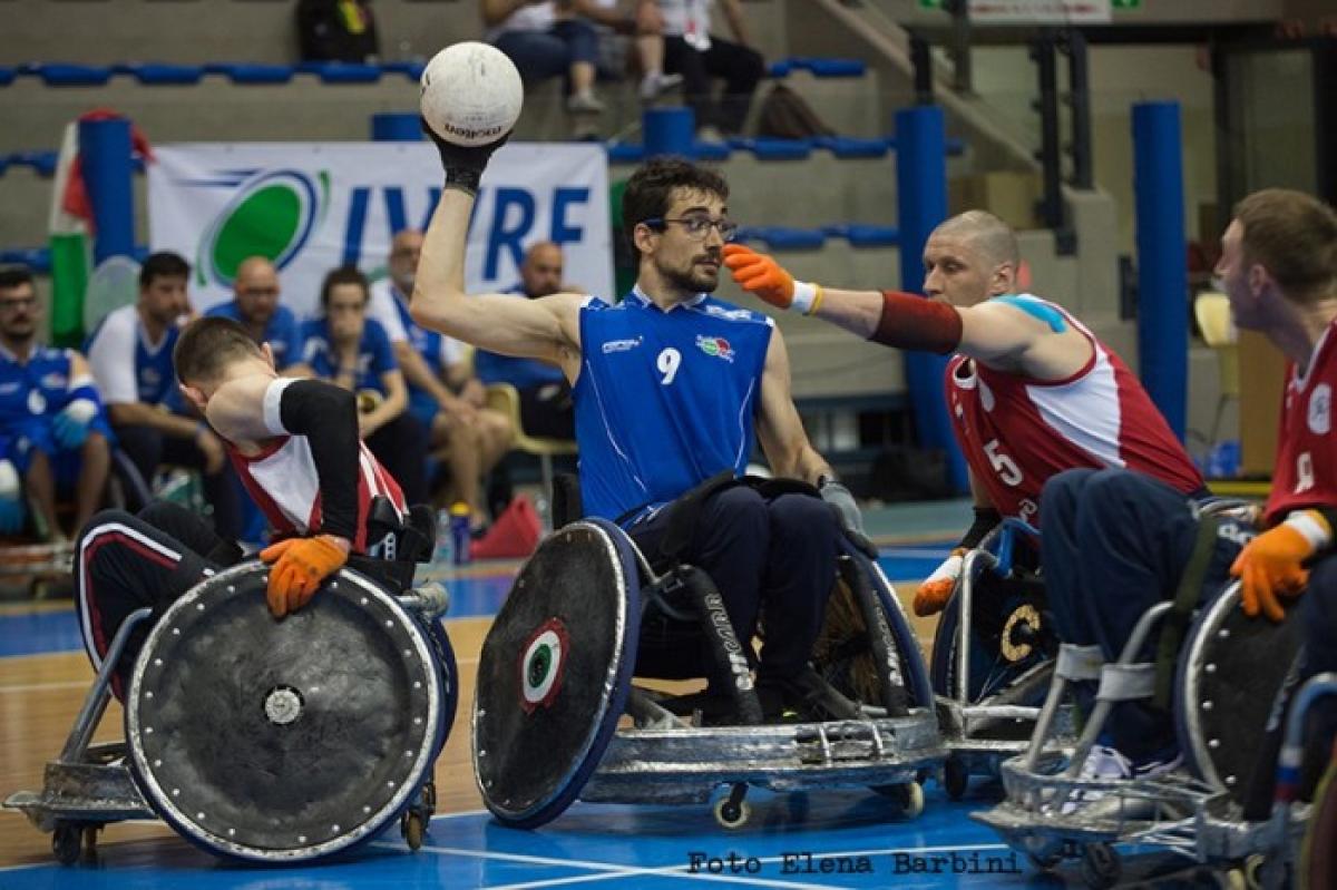 wheelchair rugby players battle for the ball