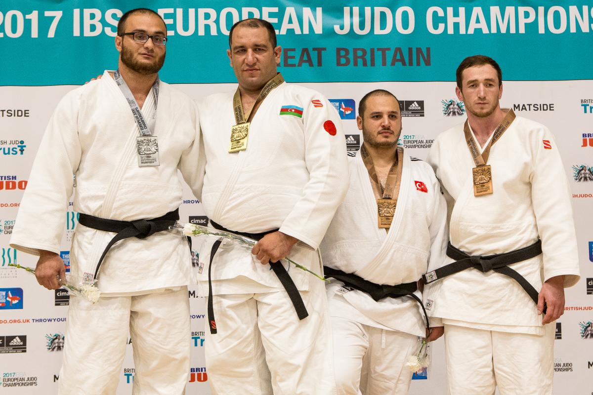Azerbaijan judo team four male judoka stand on a podium