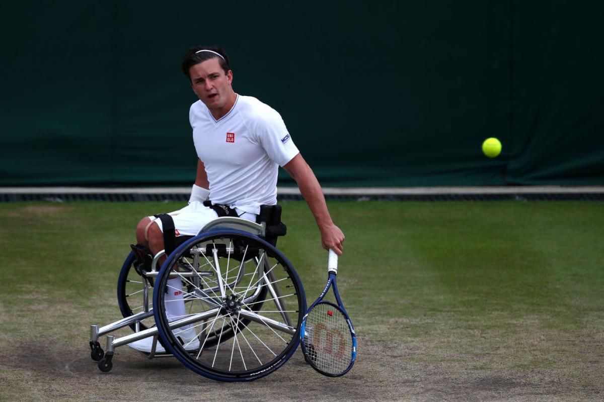 a wheelchair tennis player hits a shot