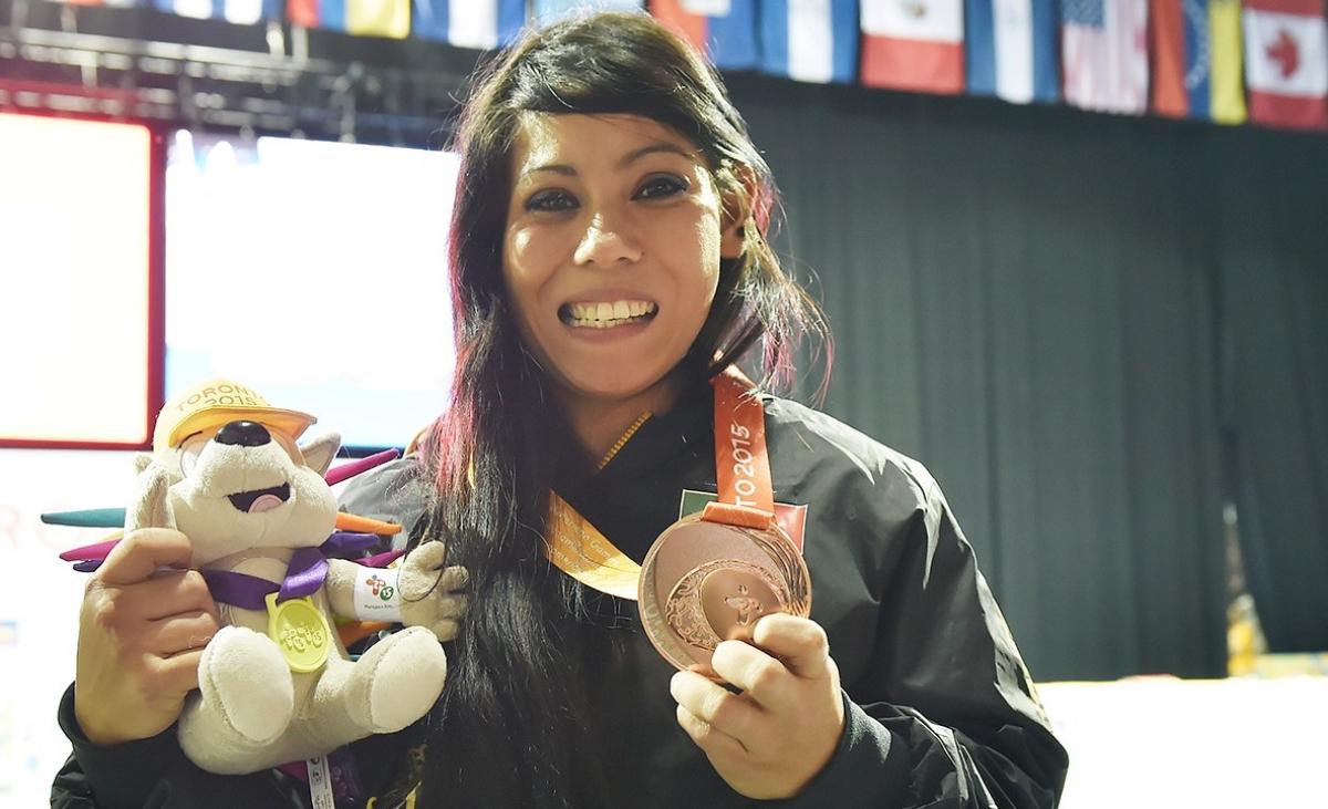 Mayra Hernandez a Para athlete holds her medal and smiles