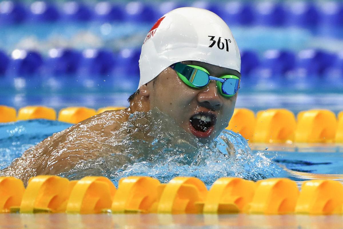 a Para swimmer takes a breath out of the water