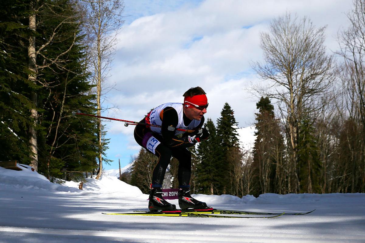 A male Para cross country skier skies across the snow