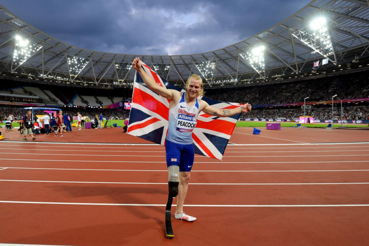 a Para sprinter celebrates winning with a Great Britain flag