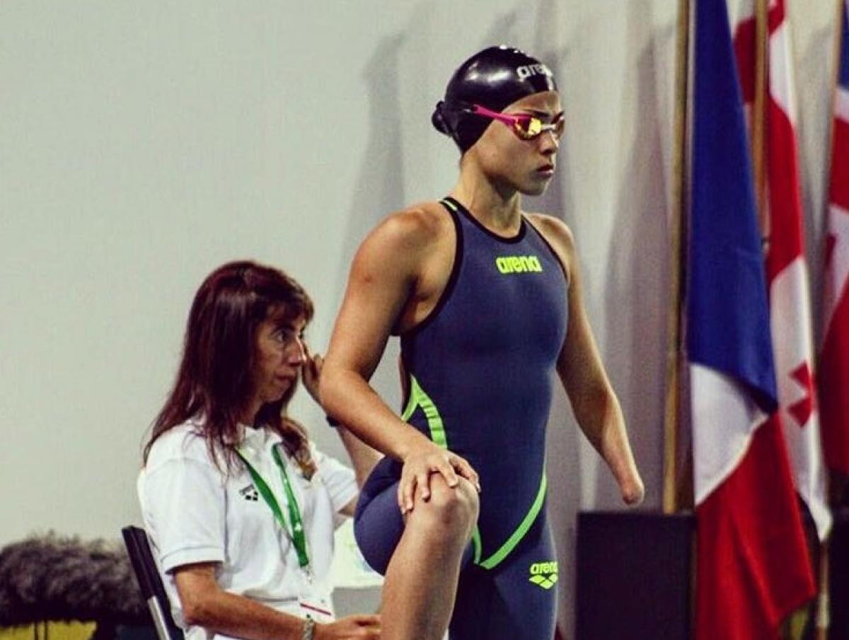 a female Para swimmer waits by her lane