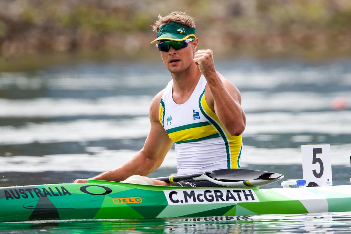 Man in canoe pumps his fist after winning