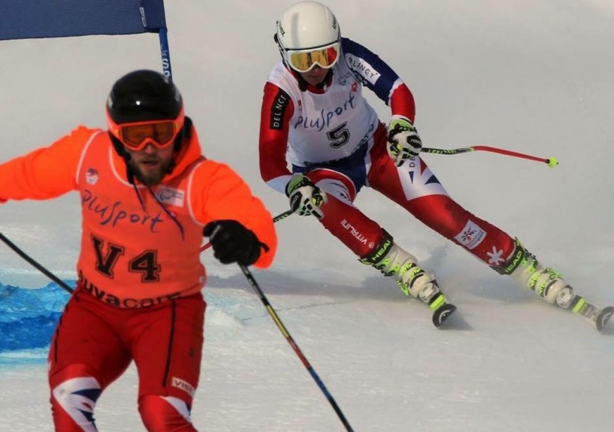 A Para skiier and her guide ski down the slope