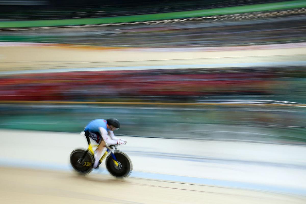 a Para cyclist speeds around the track