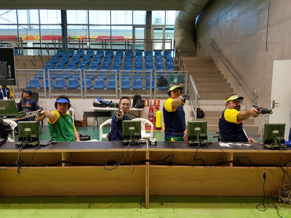 Felipe Wu tries shooting Para sport a row of male athletes compete with rifles in shooting Para sport