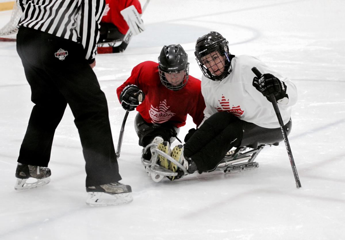 two female Para ice hockey players are given instructions on the ice